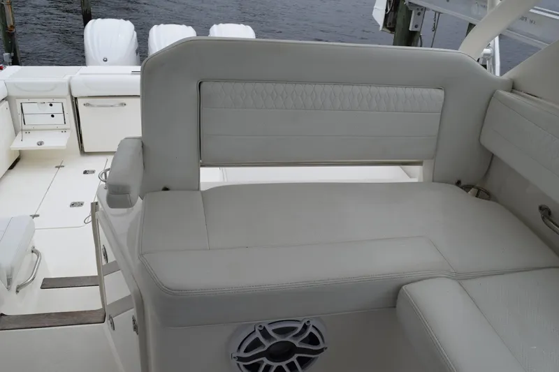 Slide: The Image of 2022 Pursuit OS 355 Offshore boat interior with white seating and storage compartments. - 227