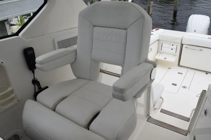 Slide: The Image of Captain's chair on 2022 Pursuit OS 355 Offshore boat, featuring luxurious white upholstery. - 252