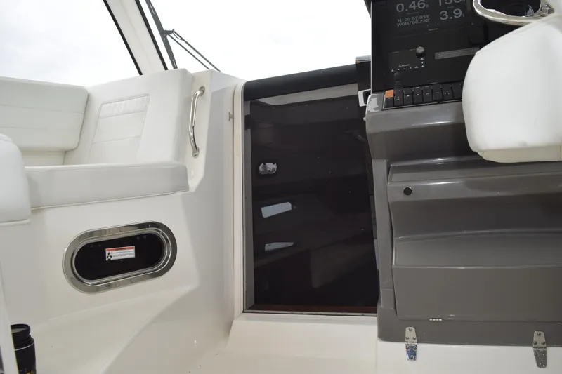 Slide: The Image of 2022 Pursuit OS 355 Offshore boat interior with white seating and control panel. - 317