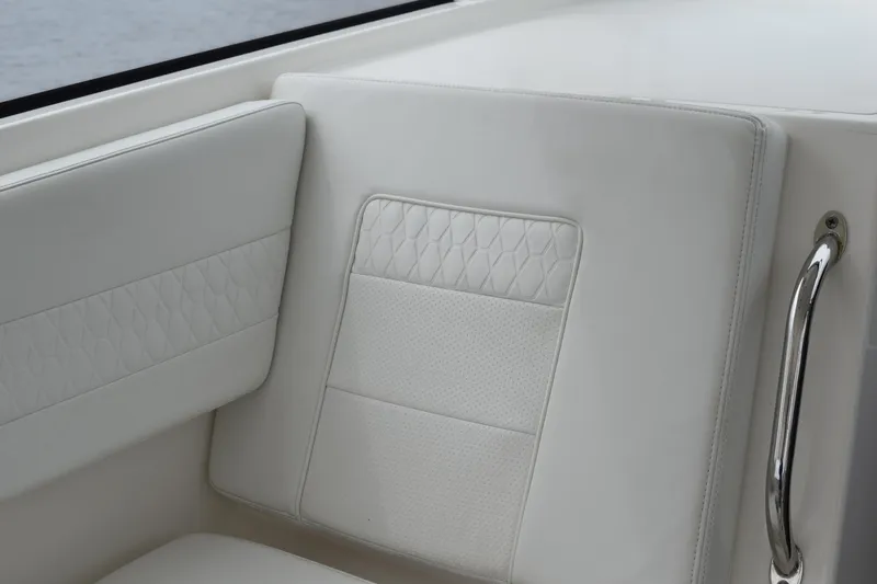 Slide: The Image of 2022 Pursuit OS 355 Offshore boat interior with white cushioned seating and stainless steel handle. - 242