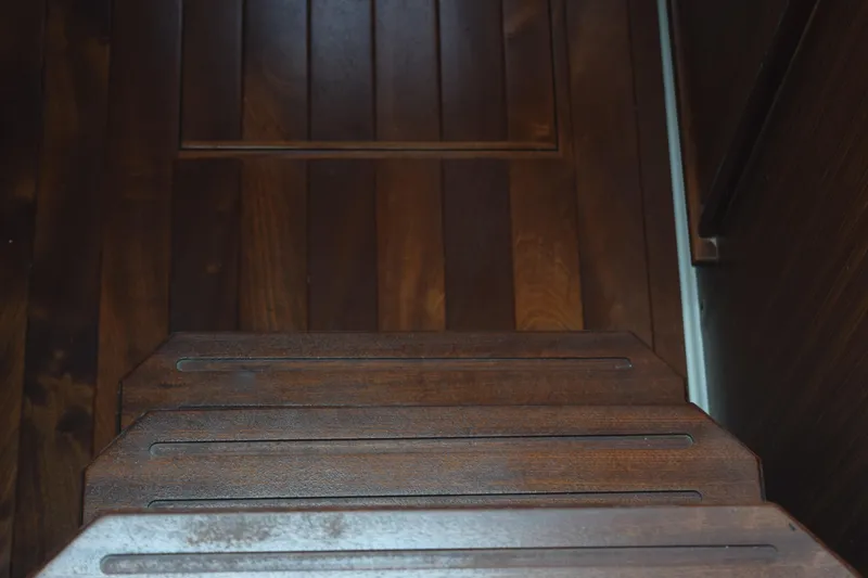 Slide: The Image of Wooden steps inside a 2022 Pursuit OS 355 Offshore boat, showcasing elegant craftsmanship. - 334
