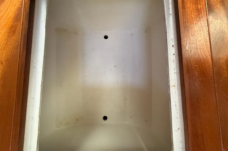 Slide: The Image of Empty storage compartment on 2022 Pursuit OS 355 Offshore boat with wooden trim. - 15