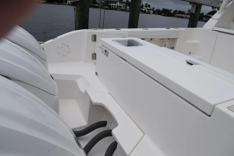 Slide: The Image of 2022 Pursuit OS 355 Offshore boat deck with engines, docked by the water. - 100