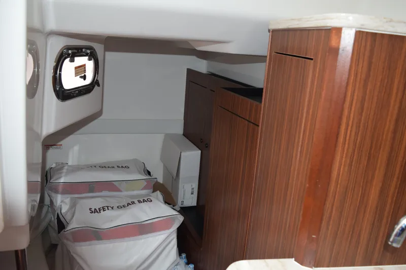 Slide: The Image of Interior cabin of 2022 Pursuit OS 355 Offshore with safety gear bags and wooden cabinetry. - 382