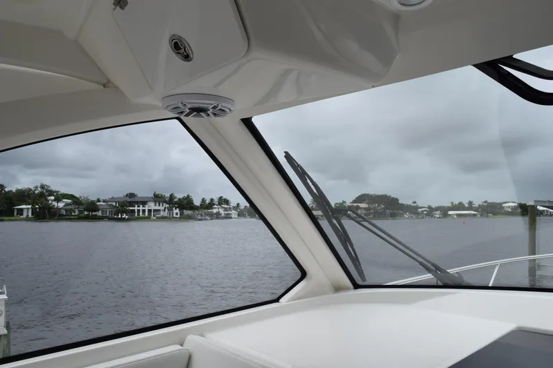 Slide: The Image of Interior view from 2022 Pursuit OS 355 Offshore boat, overlooking a waterfront with houses. - 204