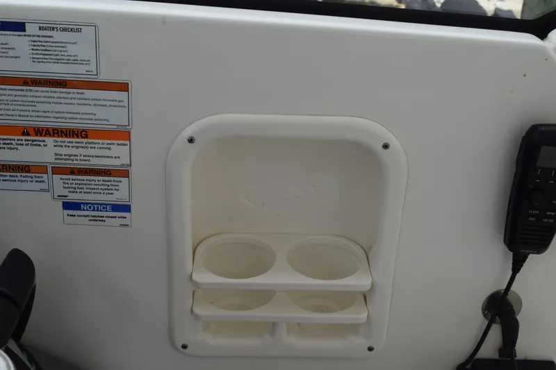 Slide: The Image of Control panel of 2022 Pursuit OS 355 Offshore boat with warning labels and cup holders. - 264