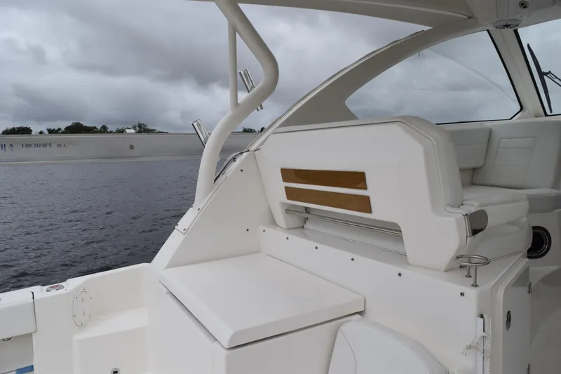 Slide: The Image of 2022 Pursuit OS 355 Offshore boat interior with white seating and wooden accents. - 158