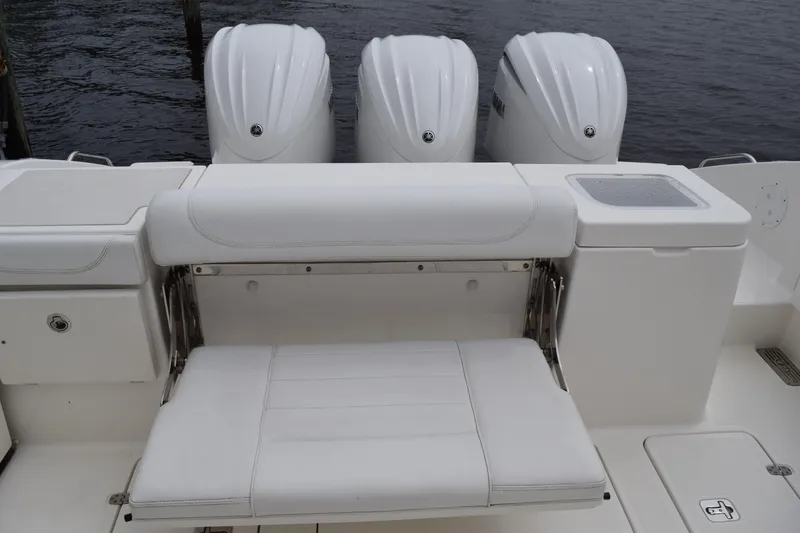Slide: The Image of 2022 Pursuit OS 355 Offshore boat with triple outboard engines and white seating. - 51