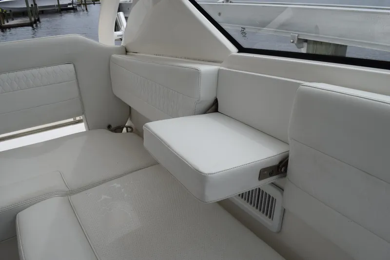 Slide: The Image of 2022 Pursuit OS 355 Offshore boat interior with white cushioned seating and armrest. - 246
