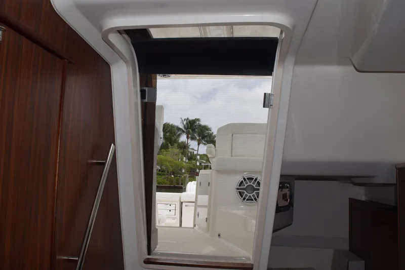 Slide: The Image of Interior view of 2022 Pursuit OS 355 Offshore boat, showing cabin entrance and outdoor seating. - 361