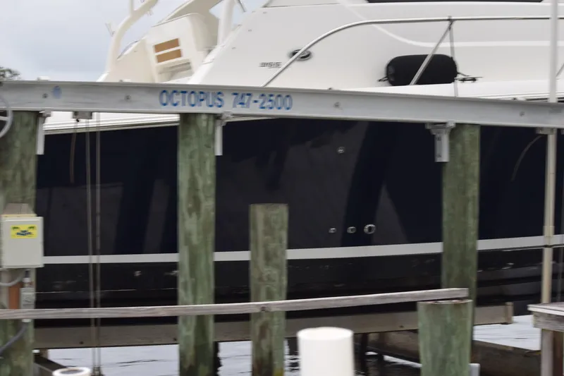 Slide: The Image of 2022 Pursuit OS 355 Offshore boat docked at marina with visible lift system. - 458