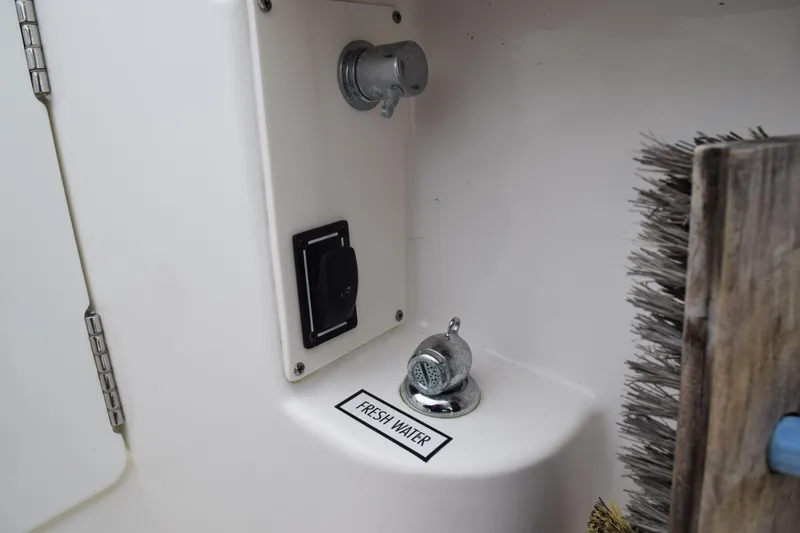 Slide: The Image of Freshwater outlet on 2022 Pursuit OS 355 Offshore boat with brush nearby. - 110