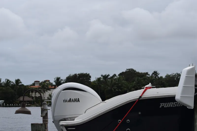 Slide: The Image of 2022 Pursuit OS 355 Offshore boat with Yamaha engine docked by waterfront homes. - 456