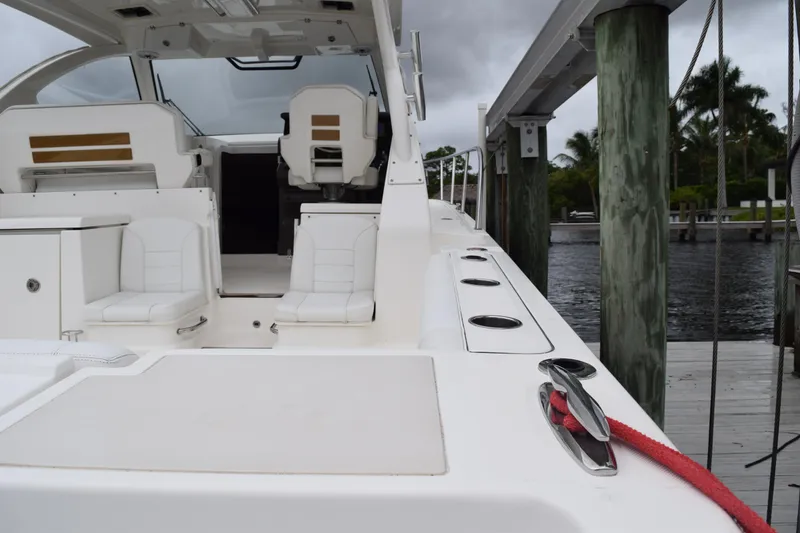 Slide: The Image of 2022 Pursuit OS 355 Offshore boat docked, featuring sleek white seating and modern design. - 97
