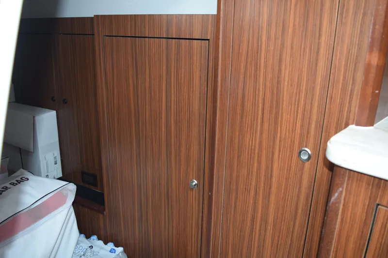 Slide: The Image of 2022 Pursuit OS 355 Offshore cabin interior with wooden cabinetry and storage. - 383