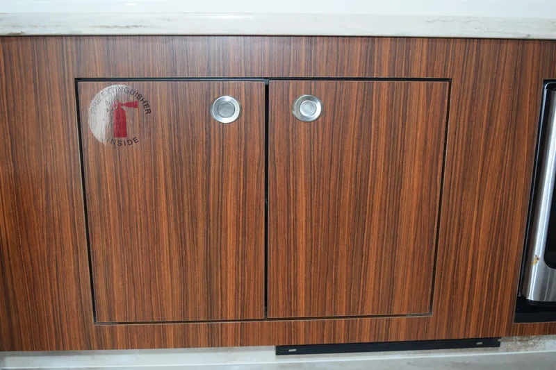 Slide: The Image of Wooden cabinet with fire extinguisher sign on 2022 Pursuit OS 355 Offshore boat. - 391