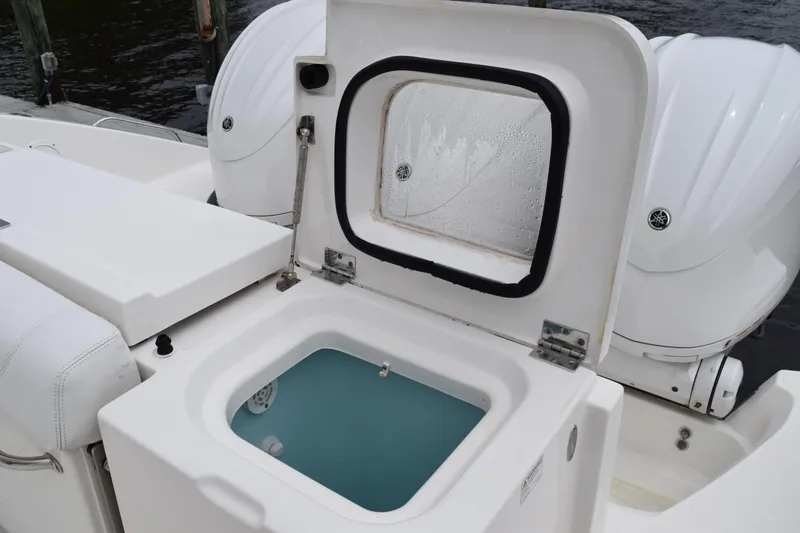 Slide: The Image of 2022 Pursuit OS 355 Offshore boat with open storage compartment and twin outboard engines. - 56