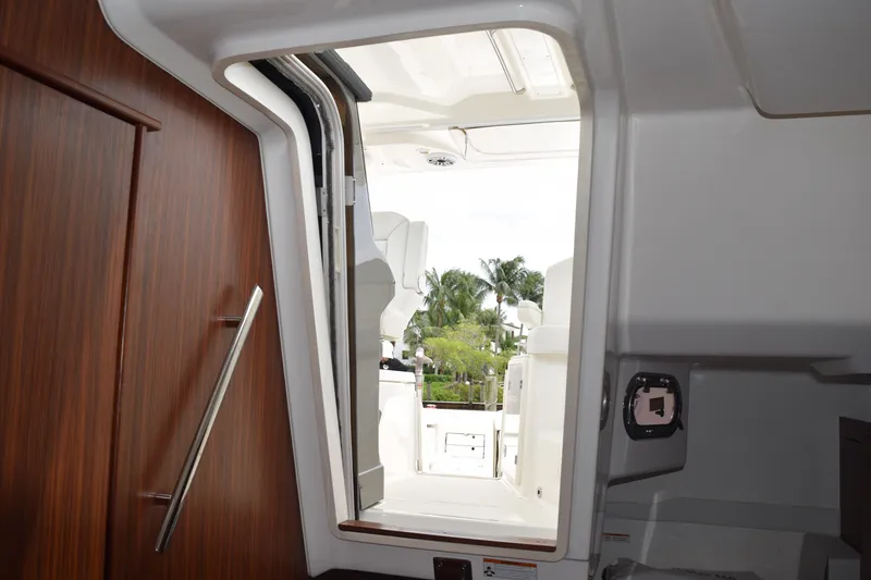 Slide: The Image of Interior view of 2022 Pursuit OS 355 Offshore boat, showing cabin entrance and outdoor seating. - 359
