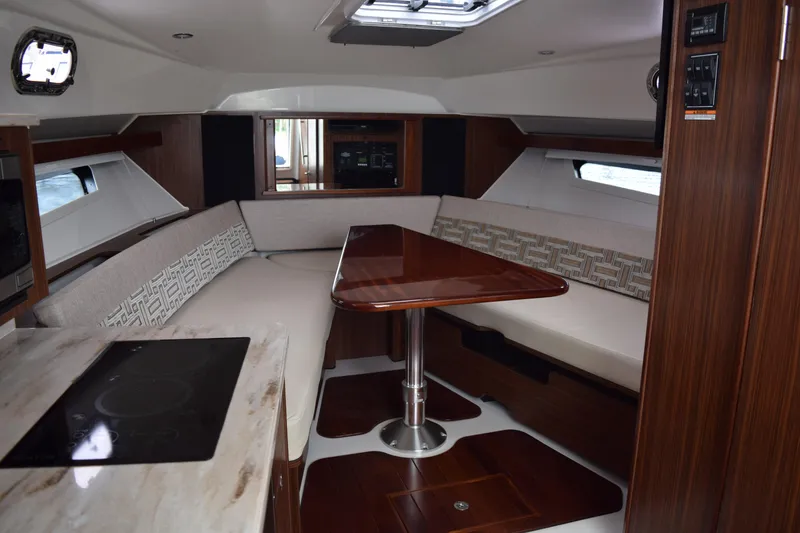 Slide: The Image of Interior of 2022 Pursuit OS 355 Offshore boat with elegant seating and wooden table. - 433