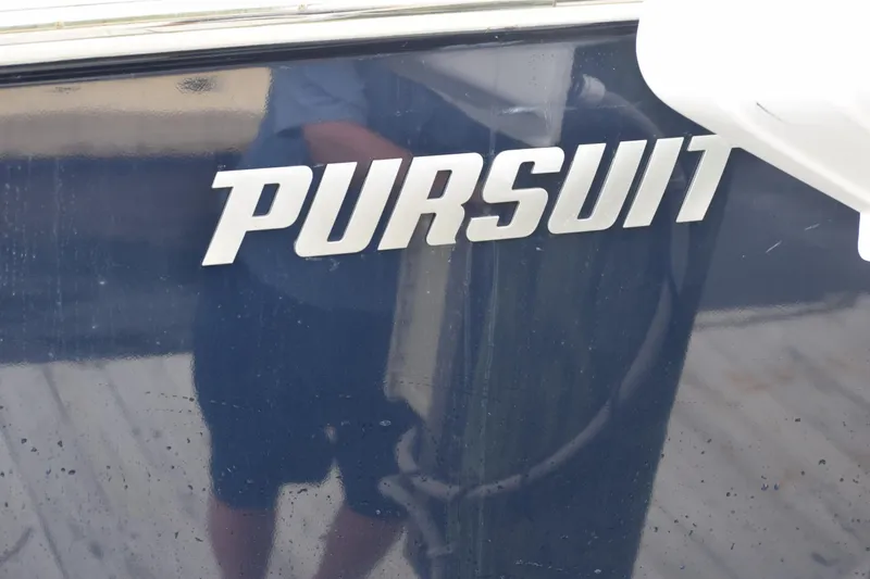 Slide: The Image of 2022 Pursuit OS 355 Offshore boat logo on dark surface. - 450