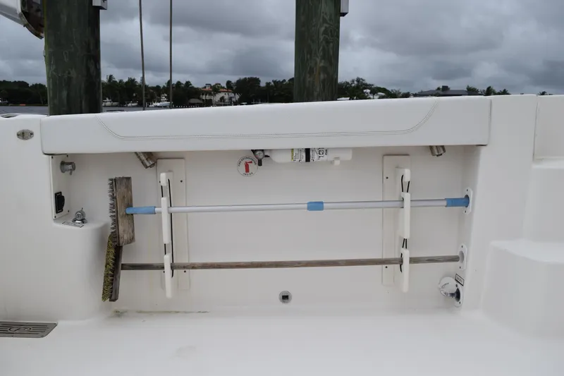 Slide: The Image of 2022 Pursuit OS 355 Offshore boat storage compartment with cleaning tools and equipment. - 115