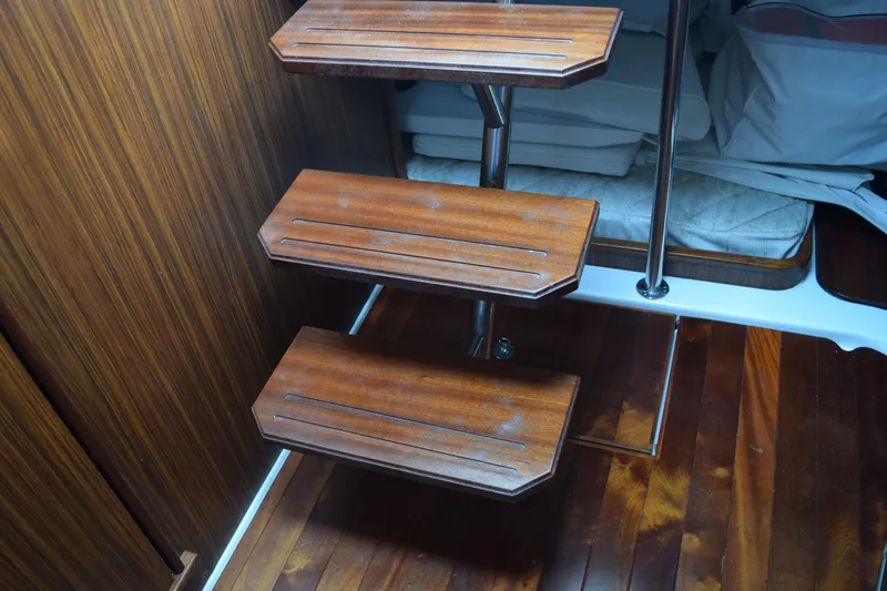 Slide: The Image of Wooden interior stairs on 2022 Pursuit OS 355 Offshore boat, leading to cabin area. - 335