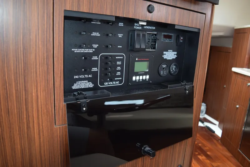 Slide: The Image of Electrical control panel inside 2022 Pursuit OS 355 Offshore boat cabin. - 410