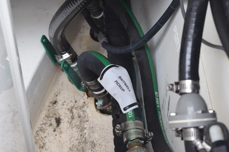 Slide: The Image of 2022 Pursuit OS 355 Offshore boat plumbing system with hoses and clamps. - 136