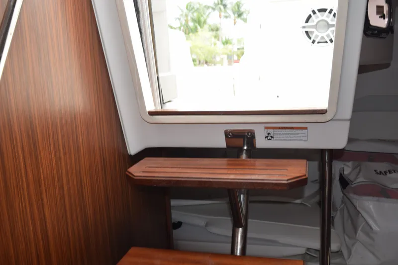 Slide: The Image of Interior view of 2022 Pursuit OS 355 Offshore boat with wooden steps and window. - 346