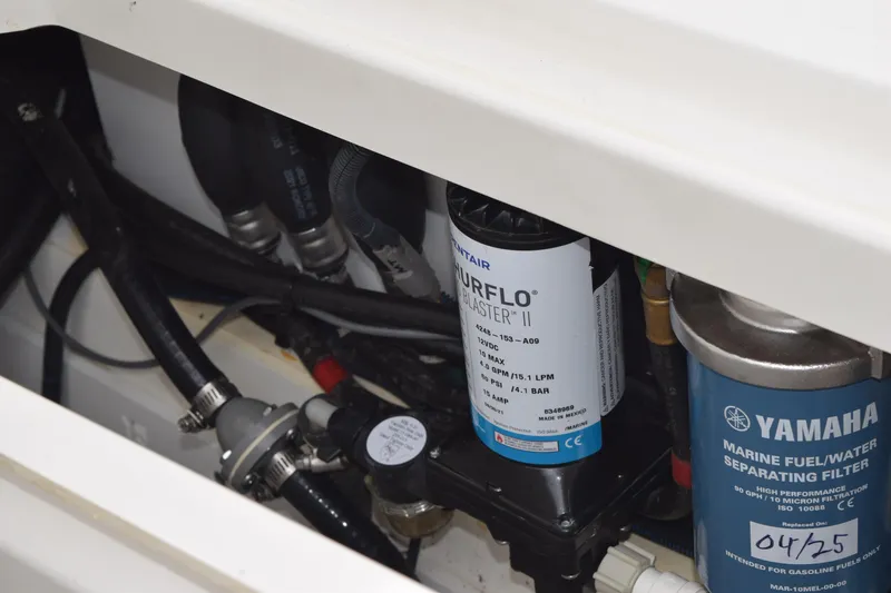 Slide: The Image of 2022 Pursuit OS 355 Offshore engine compartment with Yamaha marine fuel filter and Shurflo pump. - 135