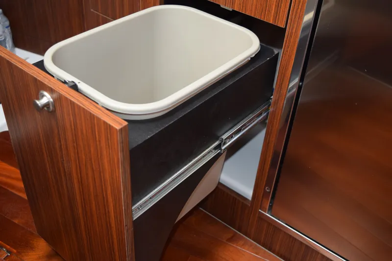 Slide: The Image of Pull-out trash bin in 2022 Pursuit OS 355 Offshore boat's wooden cabinet. - 427