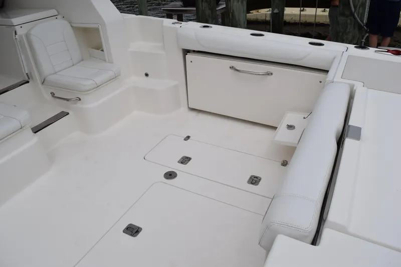 Slide: The Image of 2022 Pursuit OS 355 Offshore boat interior with white seating and storage compartments. - 64