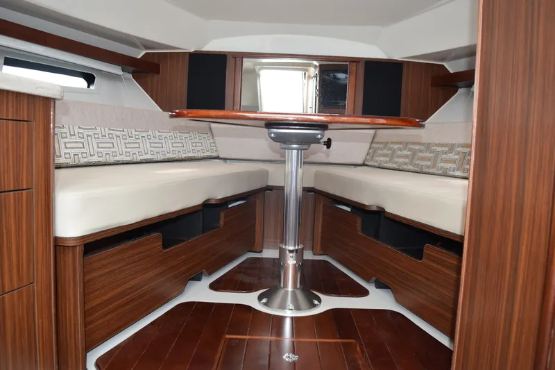 Slide: The Image of 2022 Pursuit OS 355 Offshore cabin interior with wood finish and cushioned seating. - 415