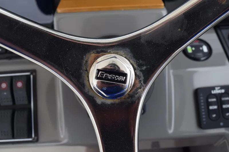 Slide: The Image of Steering wheel of 2022 Pursuit OS 355 Offshore boat, featuring Edson logo. - 300