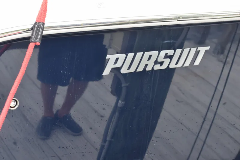 Slide: The Image of 2022 Pursuit OS 355 Offshore boat with reflective surface and red rope. - 447