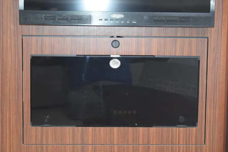Slide: The Image of 2022 Pursuit OS 355 Offshore interior with wood paneling and built-in entertainment system. - 399