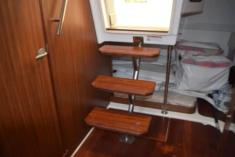 Slide: The Image of 2022 Pursuit OS 355 Offshore interior with wooden steps and safety gear. - 357