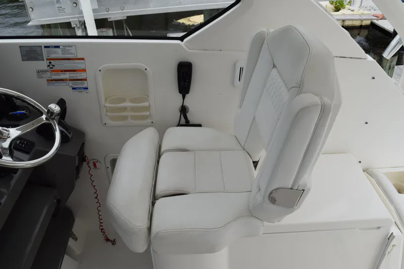 Slide: The Image of 2022 Pursuit OS 355 Offshore helm seat with steering wheel and control panel. - 249