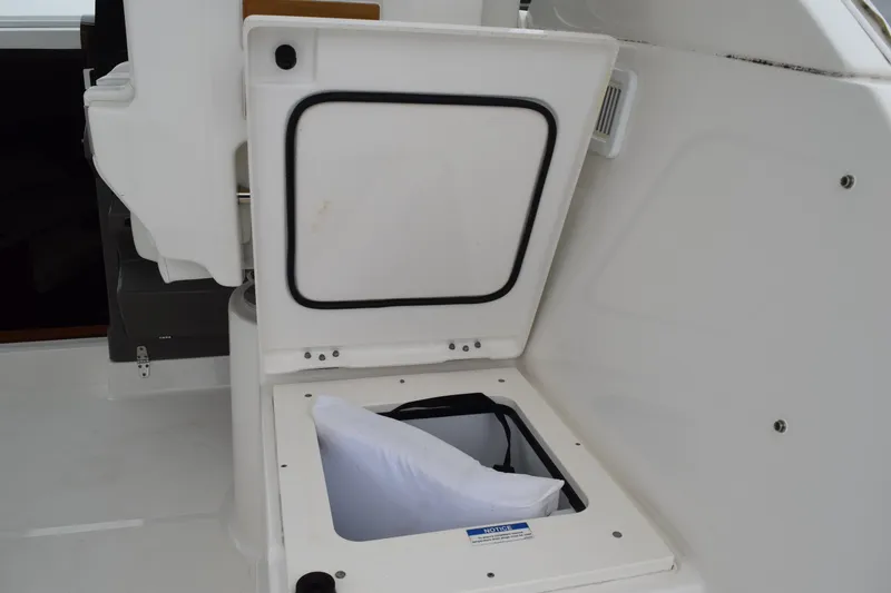 Slide: The Image of Storage compartment on 2022 Pursuit OS 355 Offshore boat, open with visible cushion inside. - 178