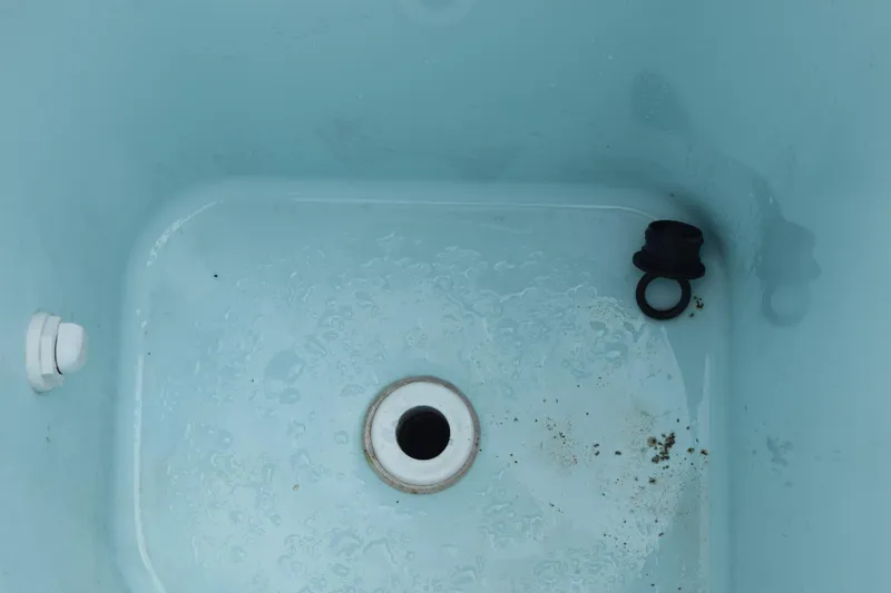 Slide: The Image of Interior of 2022 Pursuit OS 355 Offshore boat's livewell with drain and plug. - 58