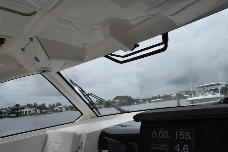 Slide: The Image of Interior view of 2022 Pursuit OS 355 Offshore boat with dashboard and waterfront scenery. - 305