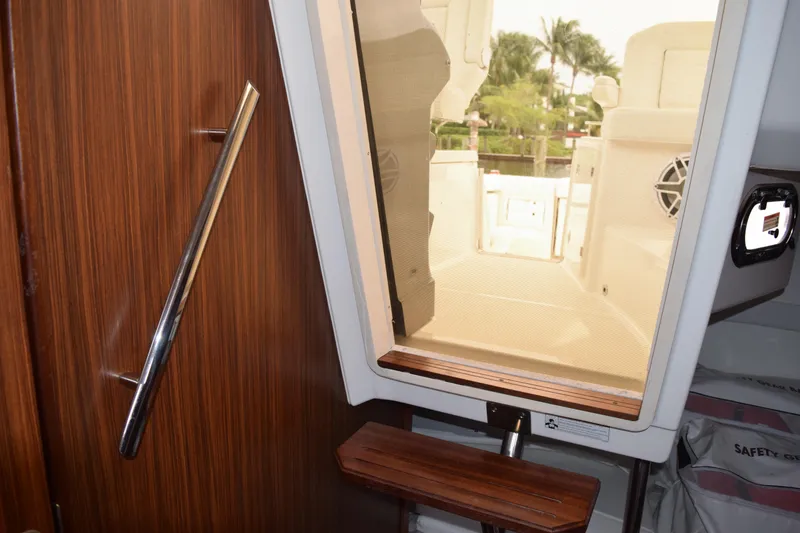 Slide: The Image of Interior view of 2022 Pursuit OS 355 Offshore boat, featuring wooden paneling and outdoor access. - 364