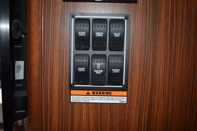 Slide: The Image of Control panel on 2022 Pursuit OS 355 Offshore boat with labeled switches and warning sign. - 370