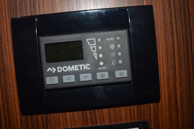 Slide: The Image of Dometic control panel on 2022 Pursuit OS 355 Offshore boat, mounted on wood panel. - 376