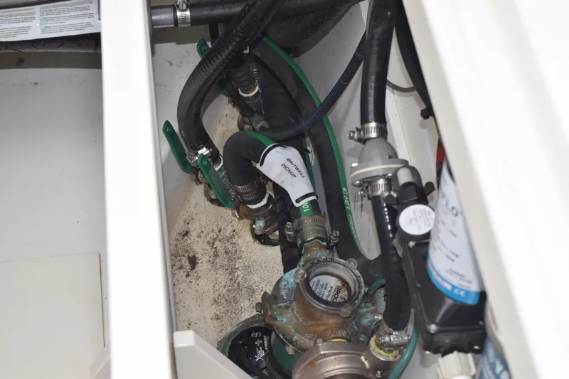 Slide: The Image of 2022 Pursuit OS 355 Offshore engine compartment with hoses and valves. - 130