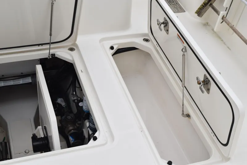 Slide: The Image of 2022 Pursuit OS 355 Offshore boat storage compartments with open hatches and visible equipment. - 150