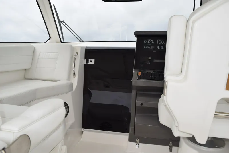 Slide: The Image of Interior of 2022 Pursuit OS 355 Offshore boat with white seating and navigation console. - 313