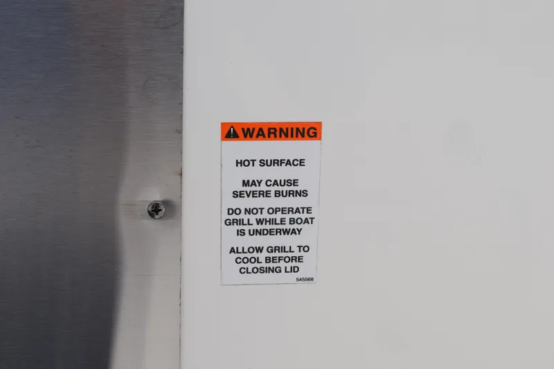 Slide: The Image of Warning label on 2022 Pursuit OS 355 Offshore boat grill, cautioning about hot surface burns. - 190