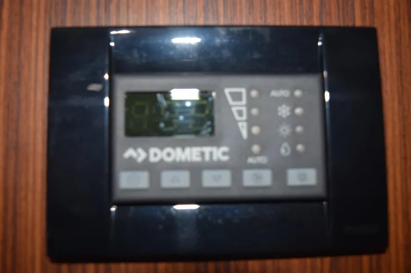 Slide: The Image of Dometic control panel on 2022 Pursuit OS 355 Offshore boat, mounted on wooden surface. - 373