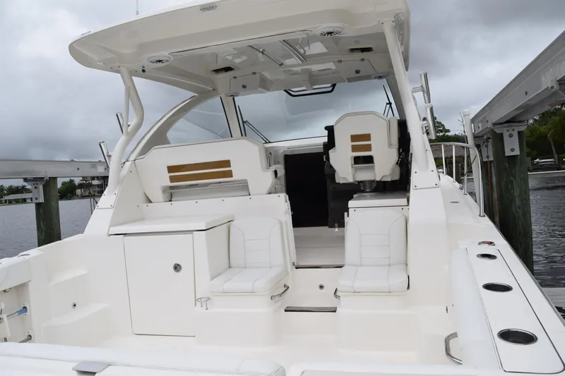 Slide: The Image of 2022 Pursuit OS 355 Offshore boat interior with white seating and helm station. - 99